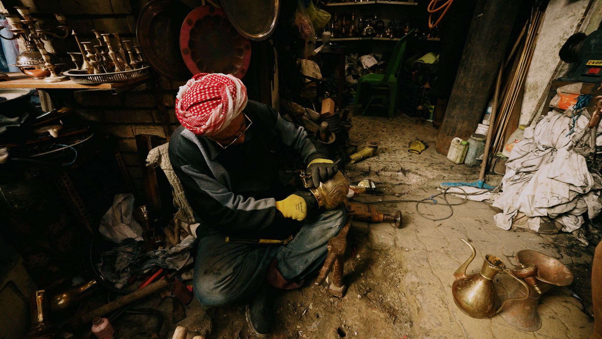 Artisan métallier travaillant une pièce en laiton dans un atelier de métallerie sur mesure